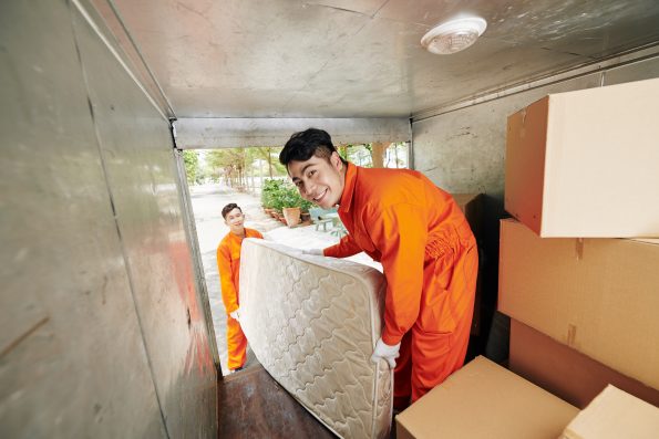 Workers loading mattress in truck